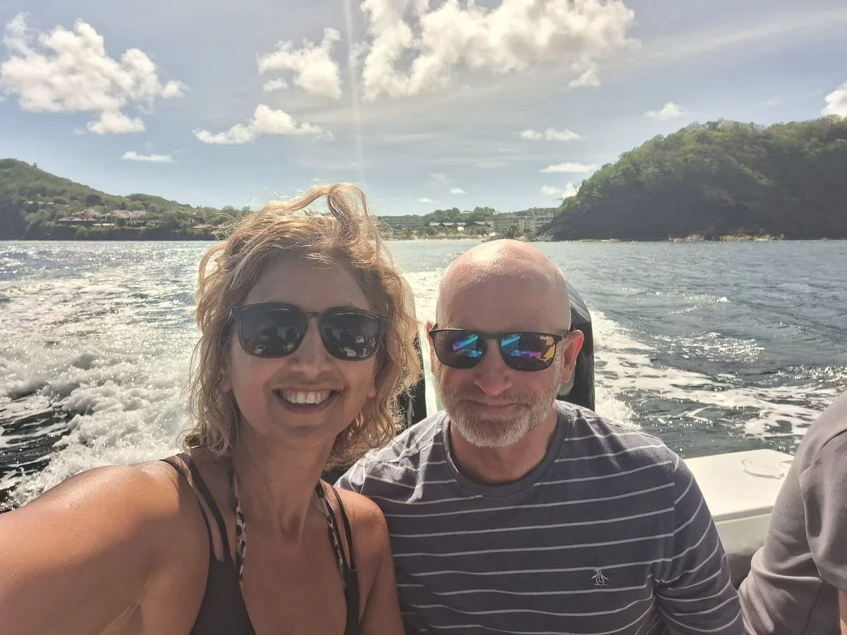 Couple smiling on a sunlit selfie aboard the Timeless II speedboat off Saint Lucia's west coast